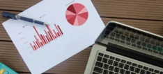 A desk with a laptop and a chart on it.