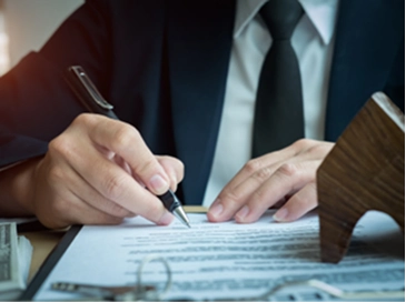 A close up of a man sitting at a desk writing.
